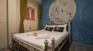 Un dormitorio con una cama con una pared azul. en 2499 Heritage Chinatown Bangkok Hotel By RoomQuest, en Bangkok