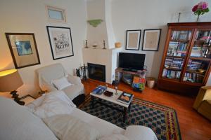 a living room with two white couches and a tv at Casa Maria Obidos in Óbidos