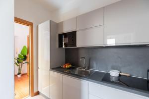 a kitchen with white cabinets and a sink at iFlat Spanish Steps Chic & Warming Hideaway in Rome