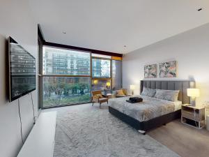 una camera da letto con un letto e una grande finestra di Aerie Stays NewQuay Collection a Melbourne Altre 160 foto