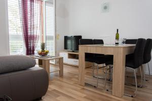 a living room with a dining room table with black chairs at Apartment Gamma with hydromassage mini pool near Split in Žrnovnica