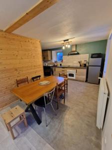 a dining room and kitchen with a table and chairs at Appartement chez Sarah in Champdivers
