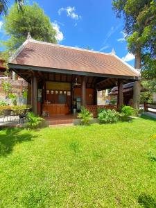 a house with a pavilion in a field of grass at Villa Sirikili Namkhan River View in Luang Prabang