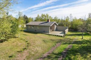 JerupにあるTV1446-Jerup-Bugten-30の庭にデッキ付きの小さな家