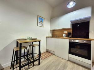 a kitchen with a counter and a table and a stove at Les loges du Beffroi- La Pellicule King Size in Arras