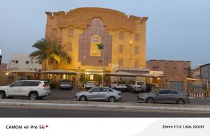 a building with cars parked in a parking lot at جولدن نيو-Golden New in Jazan