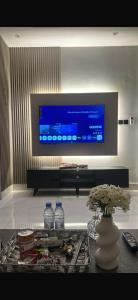 a living room with a television and water bottles on a table at استديو 3 دخول ذاتي in Jeddah