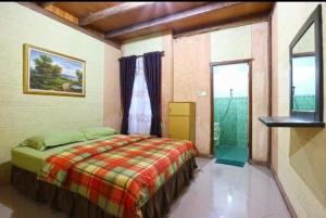 a bedroom with a bed and a large window at Jatimas Hijau Hotel & Villa in Kopo 2