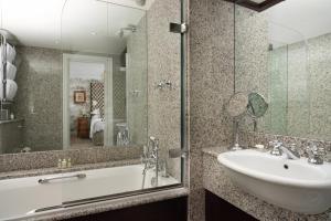 a bathroom with a sink and a tub and a mirror at The Pelham London - Starhotels Collezione in London +37 photos