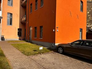 a car parked in front of an orange building at Wohnung am Auepark in Kassel