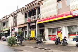 trois motocycles garés devant un bâtiment dans l'établissement Hotel O Guest House Teras Waruga Syariah, à Bandung