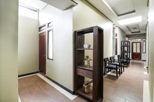 un couloir avec des chaises, une table et un miroir dans l'établissement Hotel O Guest House Teras Waruga Syariah, à Bandung