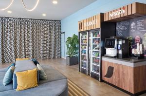 a coffee shop with a couch and a drink counter at Hesperia Sant Joan in Sant Joan Despí