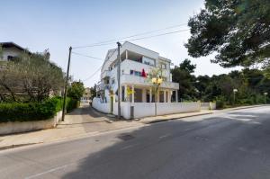 un bâtiment blanc sur le côté d'une rue dans l'établissement Apartments Borik, à Zadar