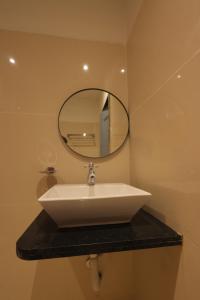 a white sink in a bathroom with a mirror at The Lotus Park in Srikalahasti +44 photos