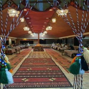 a banquet hall with a large rug on the floor at Luxury Tent in Wadi Rum