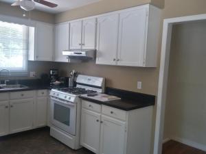 a kitchen with white cabinets and a stove top oven at Westwood Cottage License #045-2020 in Niagara-on-the-Lake