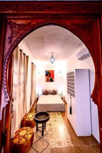 Un dormitorio con una cama y una mesa en una habitación. en Riad Dekkak, en Marrakech
