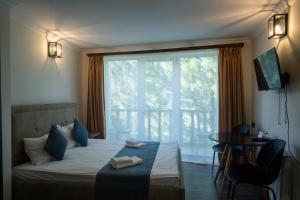 a bedroom with a bed with a large window at Casanova Inn - Boutique Hotel in Dilijan