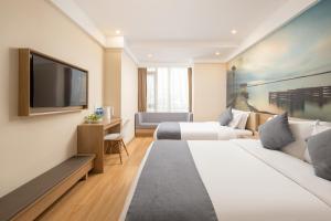 Una habitación de hotel con dos camas y un televisor de pantalla plana. en 智尚酒店杭州西湖湖滨浙一店, en Hangzhou