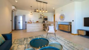 Una sala de estar con un sofá y una cocina. en Pointe d'Azur Beachfront Homes - Pereybere, en Grand Baie