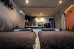 two beds in a room with a kitchen at vacation house KAGO in Fujiyoshida +42 photos
