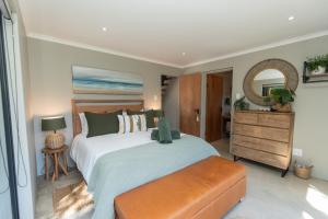 a bedroom with a large white bed and a mirror at Weaver's Nest Cottage - Nature Retreat! in Gqeberha +68 photos