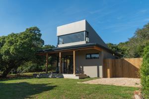 a contemporary house with a black and white facade at Weaver's Nest Cottage - Nature Retreat! in Gqeberha