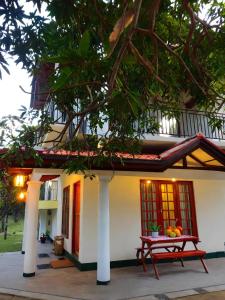 a house with a picnic table in front of it at Eco Touch Dickwella in Batigama