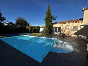 a swimming pool in front of a house at Villa Au petit baigneur - Maison avec piscine et jardin clos in Challans