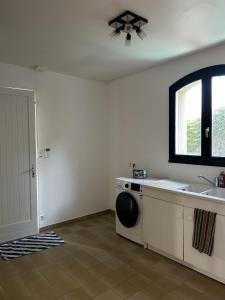 a laundry room with a sink and a washing machine at 282 - au petit baigneur in Challans