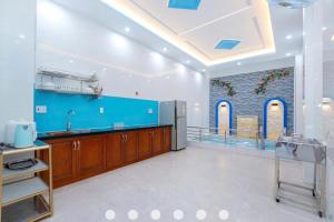 a kitchen with a sink and a blue wall at Nhà Phố Hồ Bơi Bãi Sau Gần Biển in Vung Tau