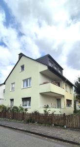 a white house with a fence in front of it at Cozy City Apartments 3, 2-Room Flat for Vacation & Messe Düsseldorf, Perfect Connectivity in Ratingen