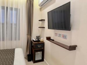 a room with a flat screen tv on a wall at Onson De Boutique Hotel in Luang Prabang