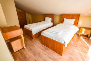 two beds in a room with wooden floors at Düzce Derdin Termal Resort & Spa in Duzce +47 photos