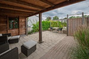 a patio with a table and chairs and a fence at 42, Cottage - Oisterwijk - Nature in Oisterwijk