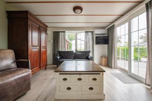 a living room with a couch and a table at 42, Cottage - Oisterwijk - Nature in Oisterwijk