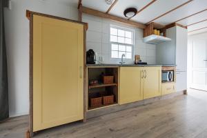 a kitchen with a yellow door in a room at 42, Cottage - Oisterwijk - Nature in Oisterwijk