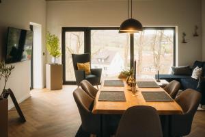 a dining room with a table and chairs and a large window at Ferienhaus Schöne Aussicht Schwarz in Edertal