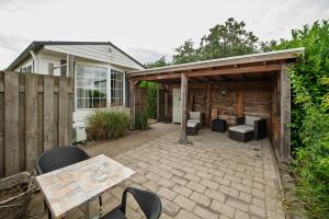 a patio with chairs and tables in front of a house at 42, Cottage - Oisterwijk - Nature in Oisterwijk +21 photos