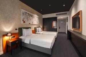 a hotel room with two beds and a television at Crowne Plaza Podgorica by IHG in Podgorica