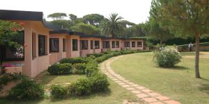 a row of houses with a walkway in a yard at Roccamare Resort - Casa di Levante in Castiglione della Pescaia