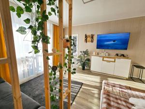 a living room with a couch and a tv at Modernes Wohlfühl-Apartment mit Stil in Mülheim an der Ruhr