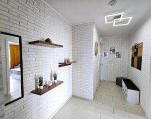 a bathroom with white brick walls and a mirror at Modernes Wohlfühl-Apartment mit Stil in Mülheim an der Ruhr