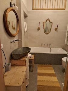 a bathroom with a sink and a tub and a mirror at Baumannhof Hasental - adults only in Plazzoles