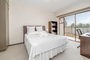 a bedroom with a large white bed with a window at Modern 3-bedroom Apartment in Broadacres Sandton in Sandton
