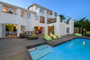 a villa with a swimming pool in front of a house at Nakai Beach Homestay in Trafalgar