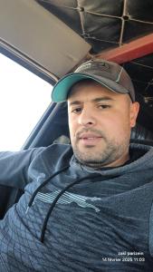 a man wearing a hat sitting in a car at Hay bensouna in Chlef