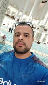 a man with glasses on his head in a swimming pool at Hay bensouna in Chlef