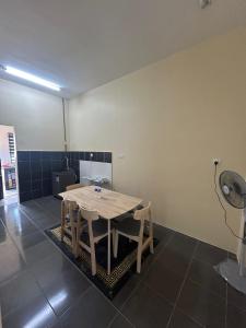 a room with a table with chairs and a fan at Singgah homestay in Gua Sai